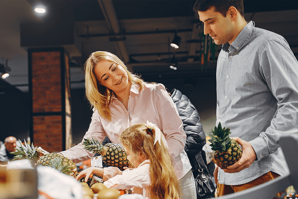 family buying pineapples in the supermarket